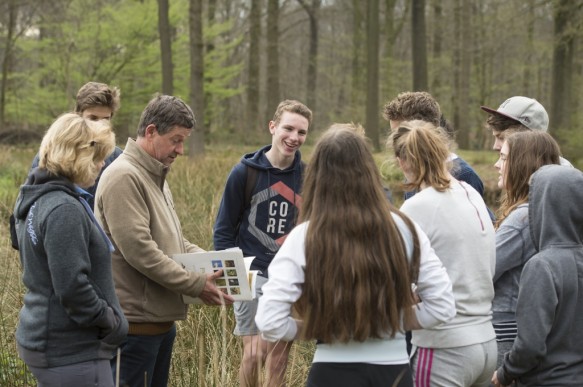 Leerlingen op stap met gids in het bos.